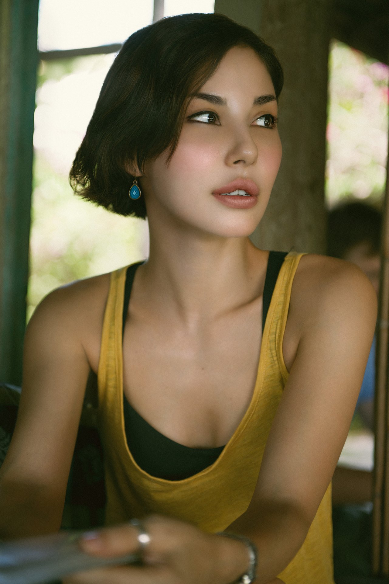 Editorial portrait in window light, yellow tank, intimate